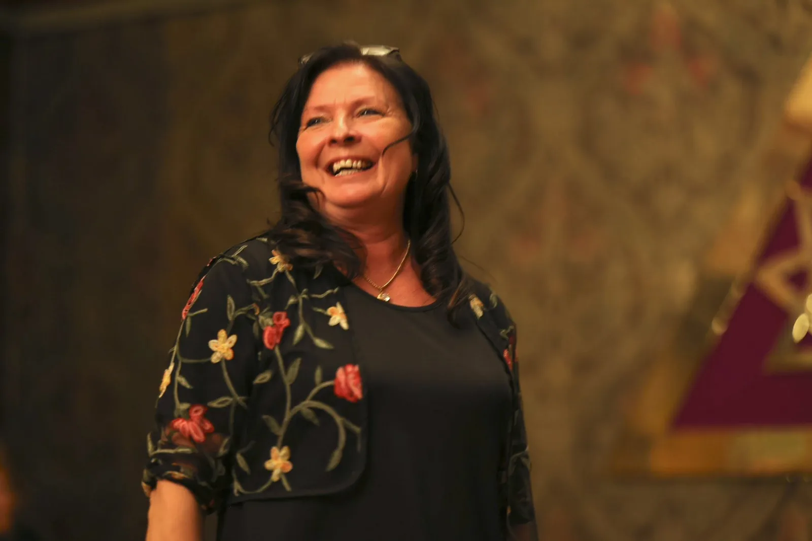 Mia Ottosson laughing warmly during a live demonstration of mediumship